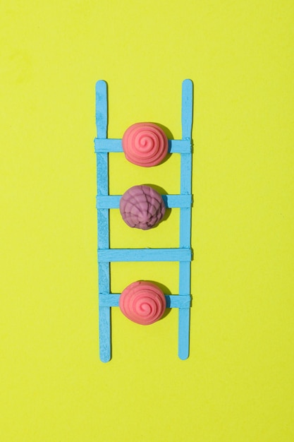 Stepladder and jelly candies on green background top view