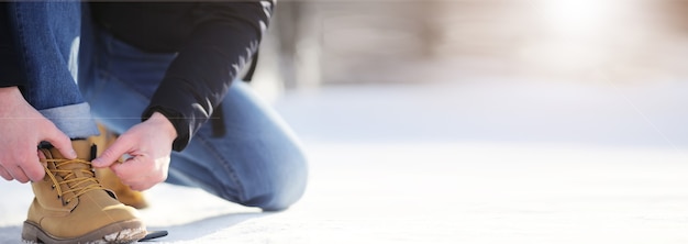 Steps along the snow-covered path. A man walks in the park in the winter.