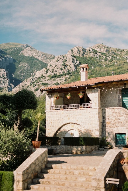 Steps to an ancient stone house with a terrace at the foot of the mountains