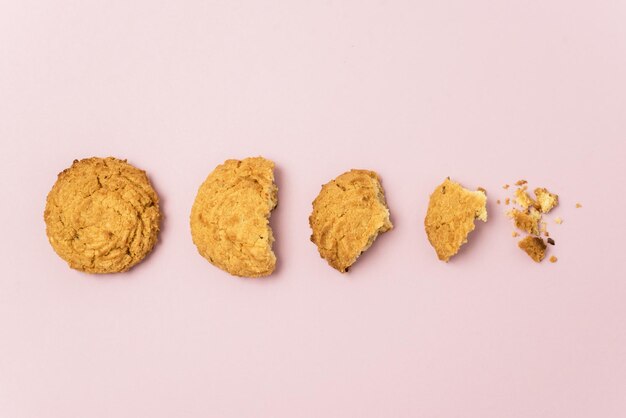 Steps of Butter Chip cookie being devoured Pink Background Horizontal