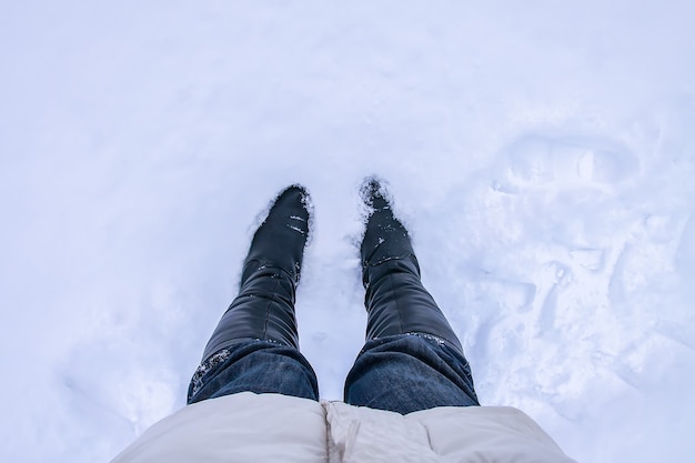 深い雪の中の階段。ドリフト中のブルージーンズの脚。