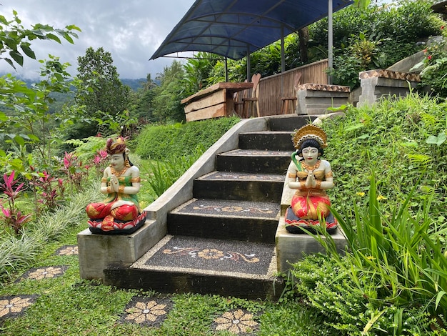 Foto gradini che conducono a un giardino con sopra un paio di statue.