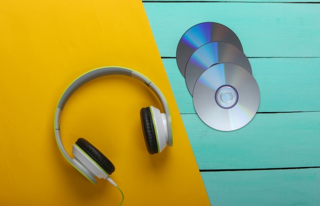 stereo headphones, cd discs on blue wooden table