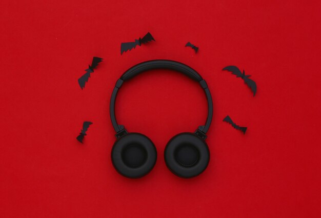 Stereo headphones with bats on red background