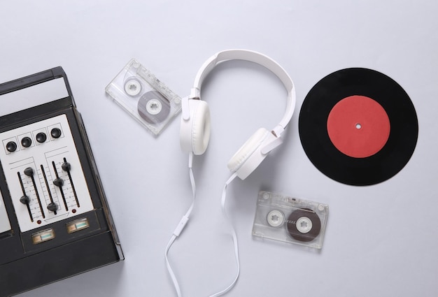 Stereo hoofdtelefoon vinyl record audiocassette en audiospeler met equalizer op een grijze achtergrond Retro stilleven bovenaanzicht