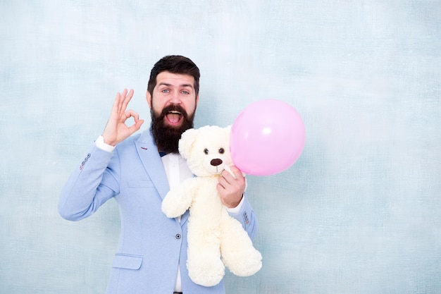 Stereotype van romantische vakantie Valentijnsdag Romantische man met teddybeer en luchtballon wachtende vriendin Romantisch cadeau Macho klaar romantische date Man slijtage smoking vlinderdas Vrouwendag