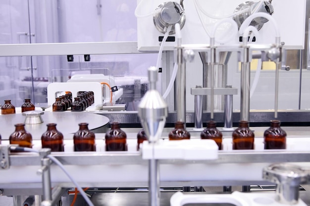 Photo sterile capsules for injection bottles on the bottling line of the pharmaceutical plant