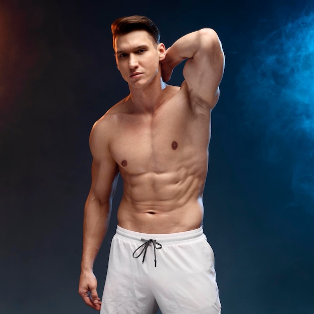 Sterk atletisch man fitnessmodel dat zijn perfecte lichaam geïsoleerd laat zien