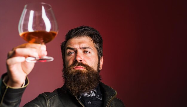 Sterke alcoholische bebaarde man met een glas whisky-degustatie en het proeven van selectieve focus kopieerruimte