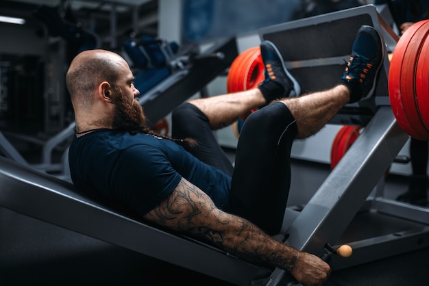 Sterke atleet op hometrainer met barbell