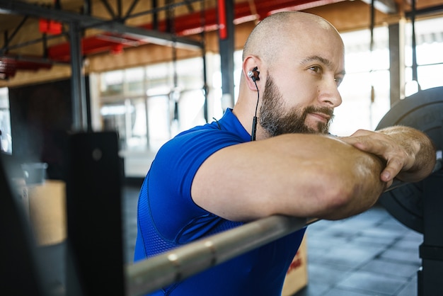 Sterke bebaarde man op een crossfit sportschool een barbell opheffen.