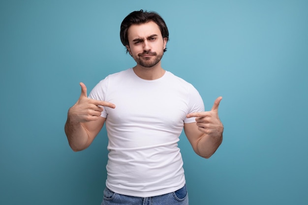 Sterke gespierde jonge man in witte t-shirt op studio achtergrond met copyspace