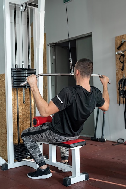 Sterke jonge atleet draagt sportkleding die traint in de sportschool