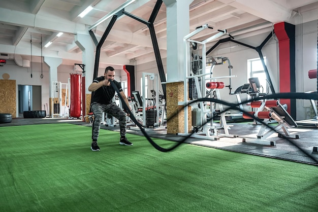 Sterke jonge atleet draagt sportkleding die traint in de sportschool