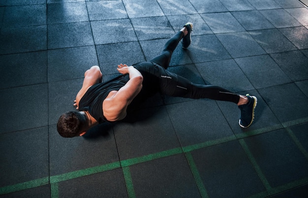 Sterke jonge man in sportieve kleding doet push-ups in de sportschool