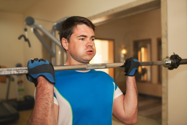 Sterke jonge man te oefenen met barbell