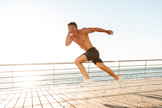 Sterke jonge shirtless sportman in oortelefoons