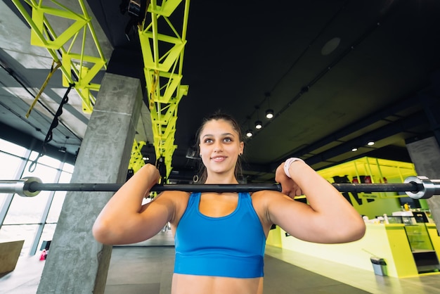 Sterke jonge vrouw die situps doet met een barbell