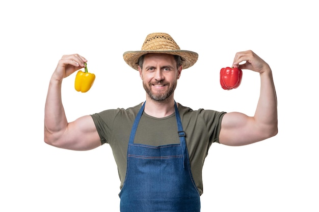 Sterke man in schort en hoed met paprika groente geïsoleerd op wit