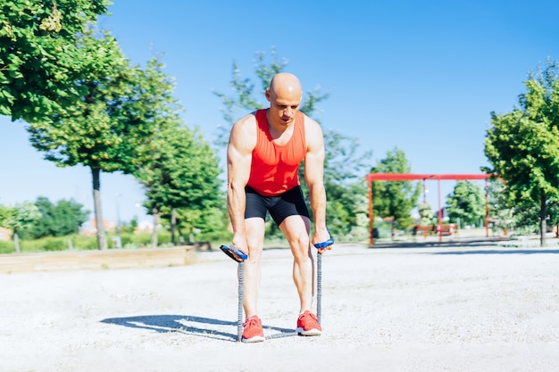 Sterke man training met elastische banden borst vooruit