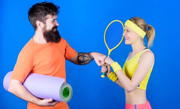 Sterke spieren en lichaam Gelukkige vrouw en bebaarde man trainen in de sportschool Sportief paar training met fitnessmat en tennisracket Sport is de beste motivatie Atletisch succes Kracht en motivatie