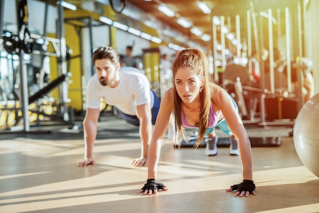 Sterke sportieve fit paar squats in de sportschool doen. Doelen van het paar.