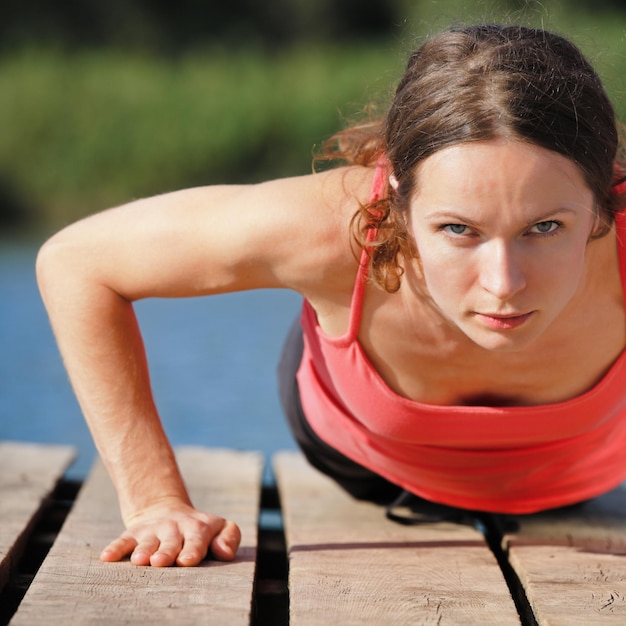 Sterke sportieve vrouw doet push-ups buitenshuis
