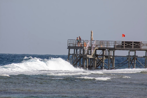 Foto sterke zeegolven slaan tegen de houten pier