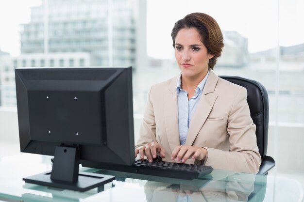 Stern businesswoman sitting in front of computer