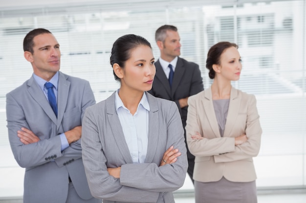 Stern work team crossing arms and looking away