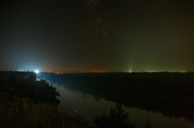 Sterren aan de nachtelijke hemel boven de rivier.