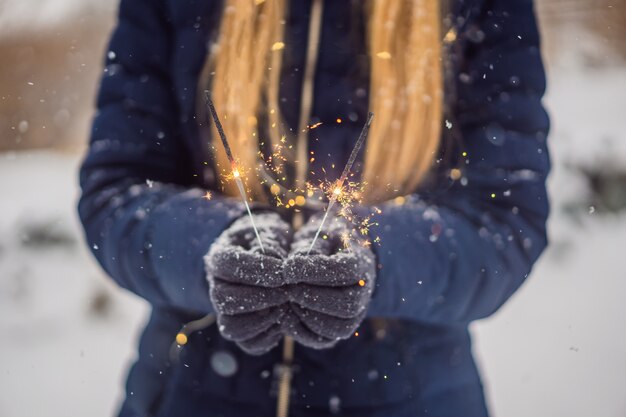 Sterretjes in vrouwelijke handen op een achtergrond van sneeuwval. Kerstmis en Nieuwjaar