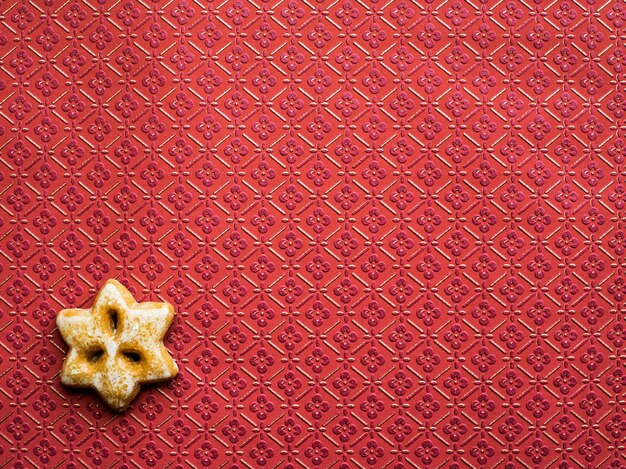 Foto stervormig peperkoekje op een bruine muur met patroon