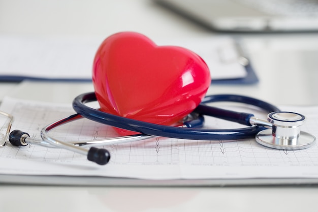 Stethescope en rood hart liggend op cardiogram. Gezondheidszorg, cardiologie en mediaconcept