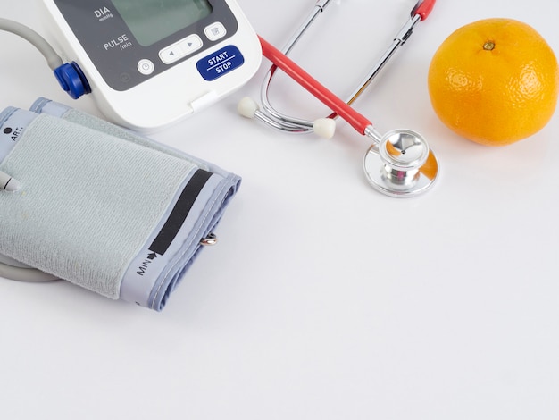 Stethoscoop en automatische bloeddrukmeter met sinaasappels