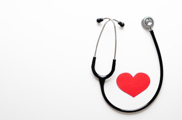 Stethoscoop en een rood papieren hart op witte achtergrond Healthcare concept bovenkant met kopieerruimte