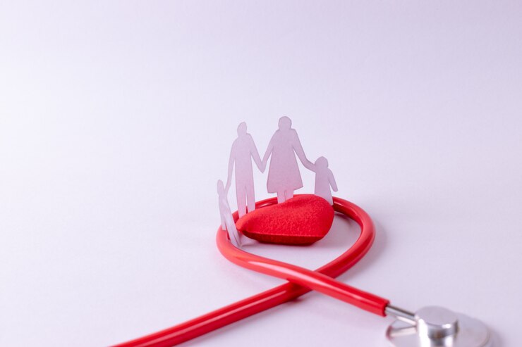 Stethoscoop gewikkeld rond rood hart en familie figuur op wit papier