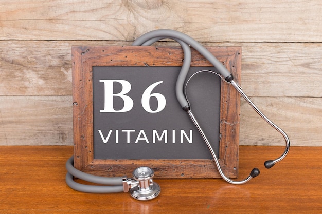 Stethoscope and blackboard with text Vitamin B6 on wooden background