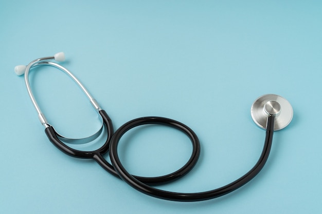 A stethoscope on blue background. Copy space.