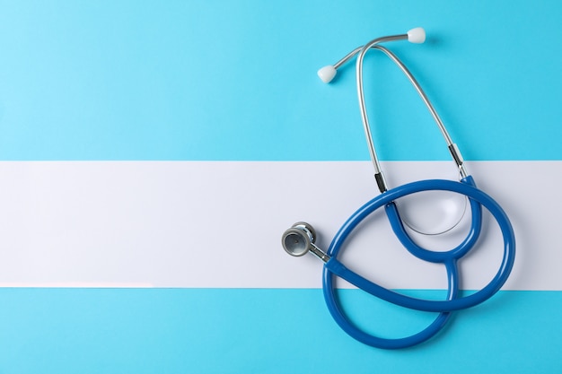 Stethoscope on blue background, space for text. Healthcare