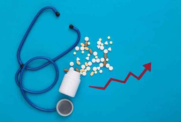 Stethoscope and Bottle of pills with growth arrow tending up on a blue