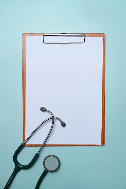 Stethoscope and clipboard on blue background