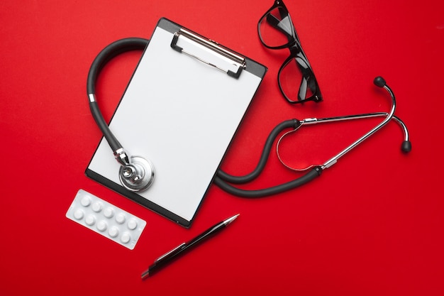 Stethoscope, clipboard and pills, closeup. Medical equipment