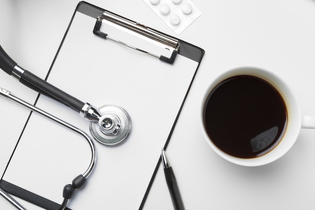 Stethoscope, clipboard and pills