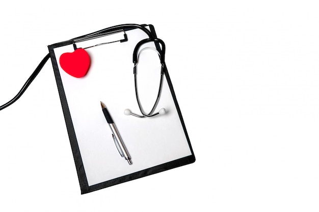 Stethoscope, clipboard with medical form lying on hospital reception desk