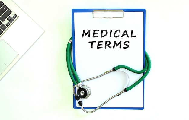 Stethoscope and clipboard with MEDICAL TERMS text on white sheet of paper and copy space.