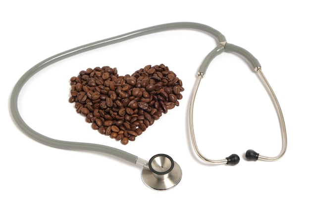 Stethoscope and coffee beans in form heart on white background.Concept heart disease and addiction.