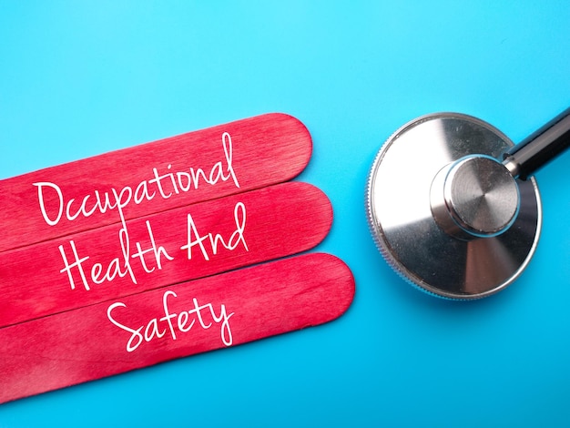 Stethoscope and colored ice cream sticks with text Occupational Health and Safety on blue background