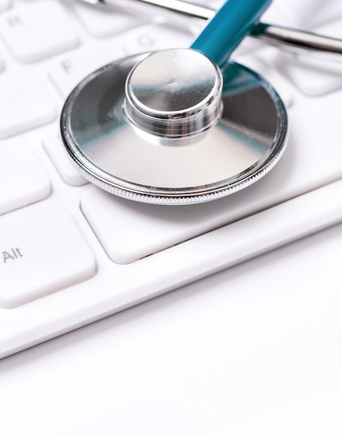 Stethoscope on computer keyboard. Physician write medical case long term care treatment concept close up macro copy space