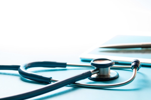 Photo stethoscope and digital tablet with pen on colored background